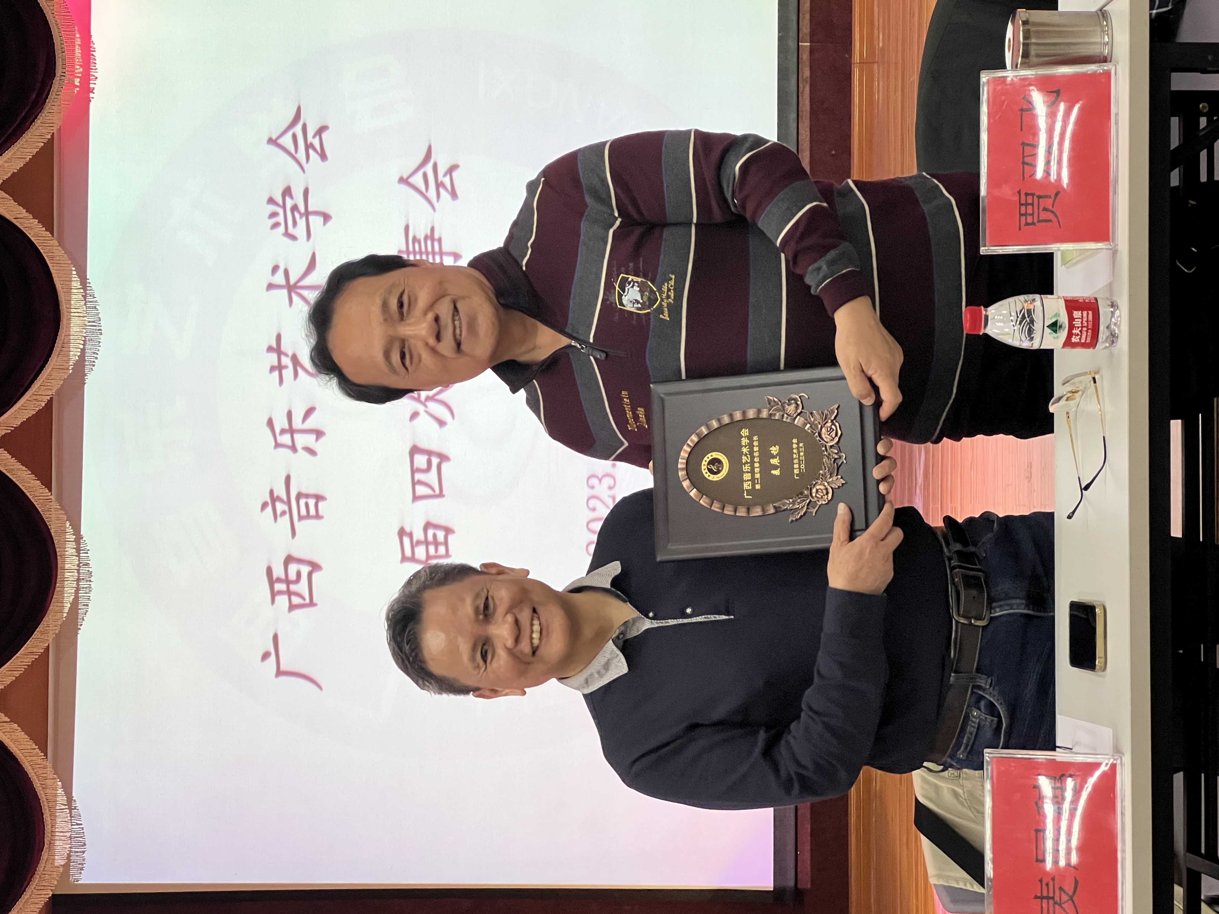 新任会长贾双飞为麦展穗颁发名誉会长牌匾
